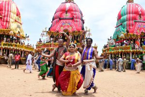 Dancers dance in front of chariots to show their devotion