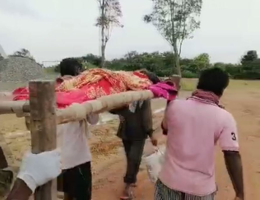 Family Members Carry Elderly Patient On Cot