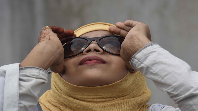 Science enthusiasts watch "ring of fire" solar eclipse unfolding in the skies of Patna using x-ray films and sunglasses on June 21, 2020. A solar eclipse occurs on a new moon day when it comes in between the earth and the sun and all the three objects are aligned. An annular solar eclipse occurs when the angular diameter of the moon falls short of that of the sun and it fails to cover up the latter completely. As a result a ring of the sun's disk remains visible around the moon. Patna witnessed a partial phase of the annular solar eclipse from 9 a.m.