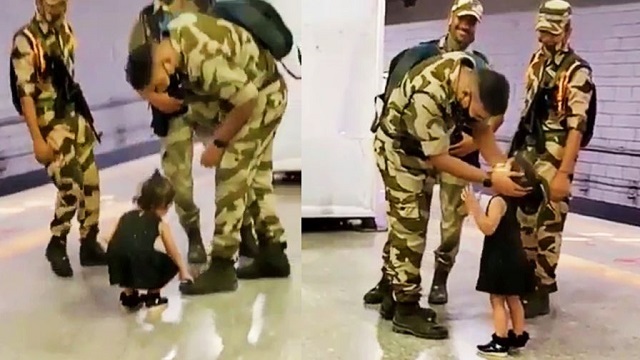 little girl touches the feet of a soldier