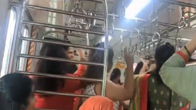 women perform garba on local train