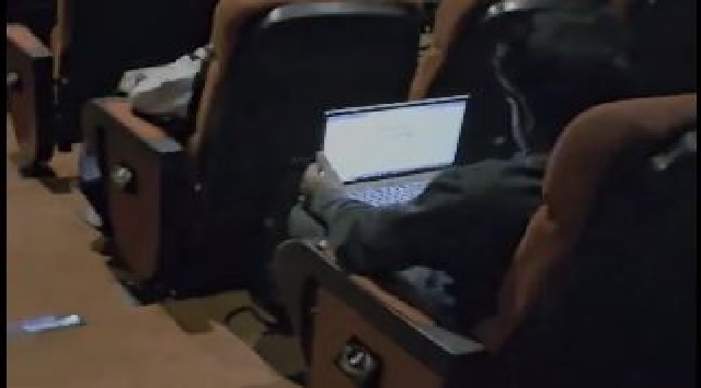 Man working on Laptop in cinema hall